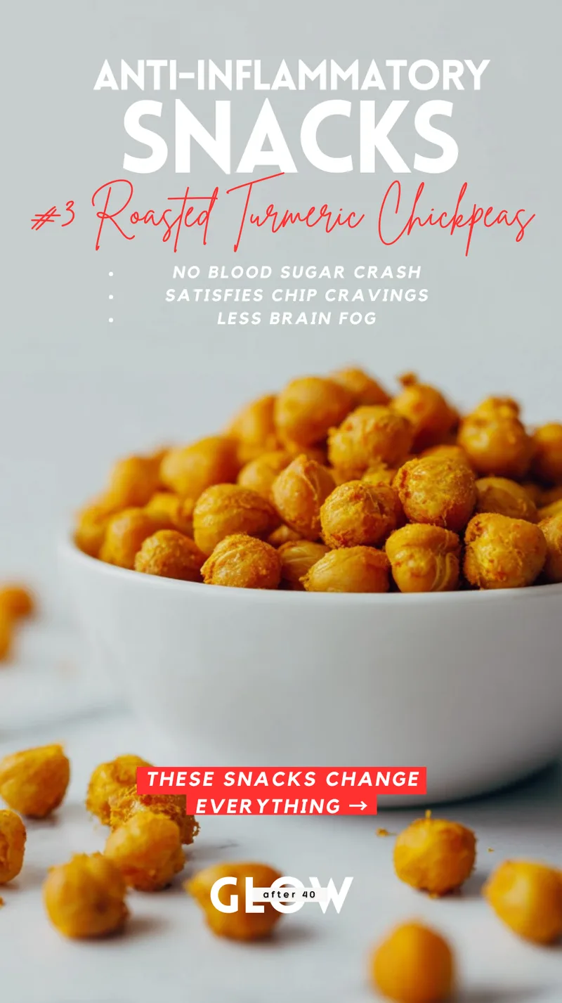 A white bowl overflowing with bright yellow-orange roasted chickpeas seasoned with turmeric, sitting on a white marble surface. Text overlays highlight benefits such as no blood sugar crash, satisfying chip cravings, and less brain fog.
